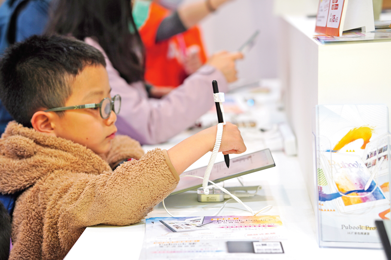 台北國際書展上孩子試用電子書閱讀器。謝平平攝影