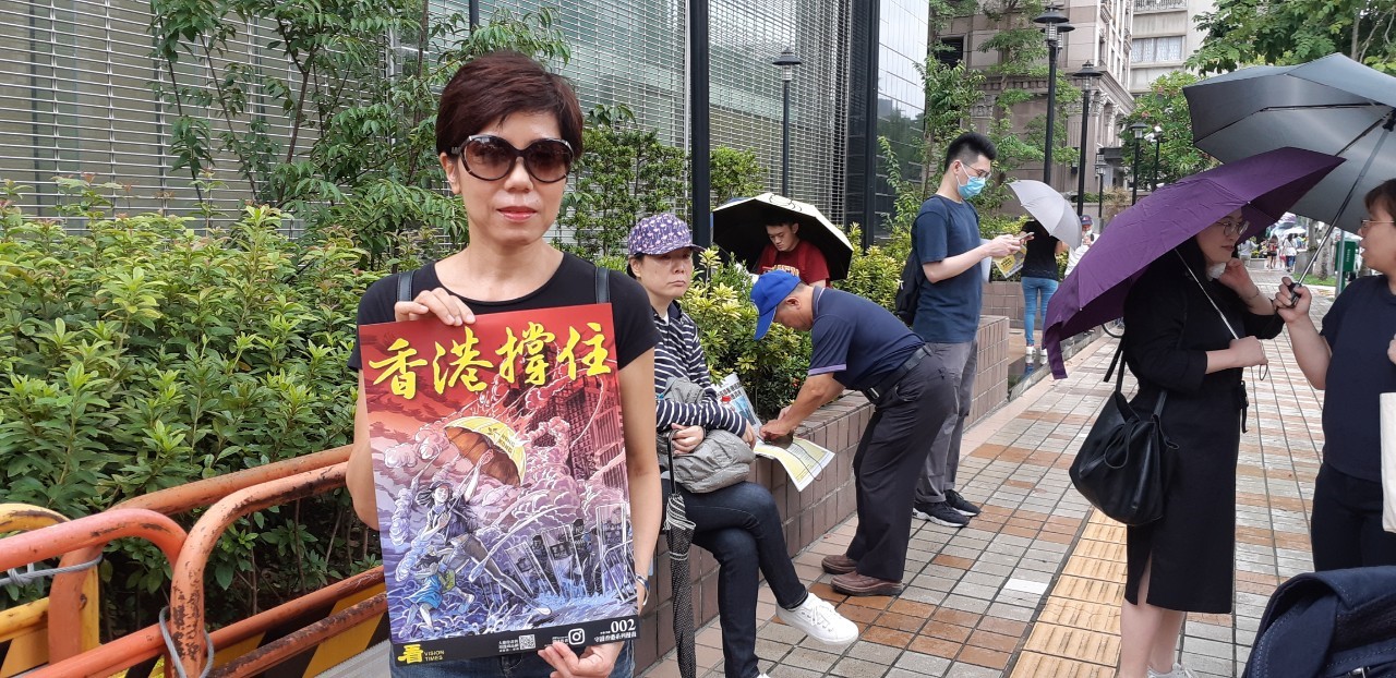 民眾拿「香港撐住」的海報。楊戎真攝影