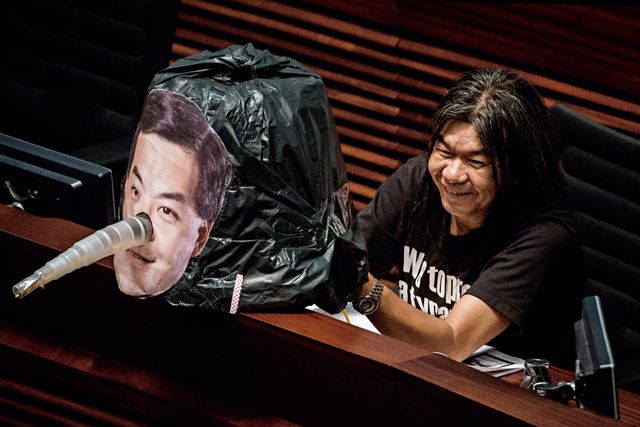 被稱為「長毛」的香港親民主派立法會議員梁國雄，在立法會中以象徵說謊的長鼻子固定在特首梁振英的圖片上，作為諷刺。Getty Images