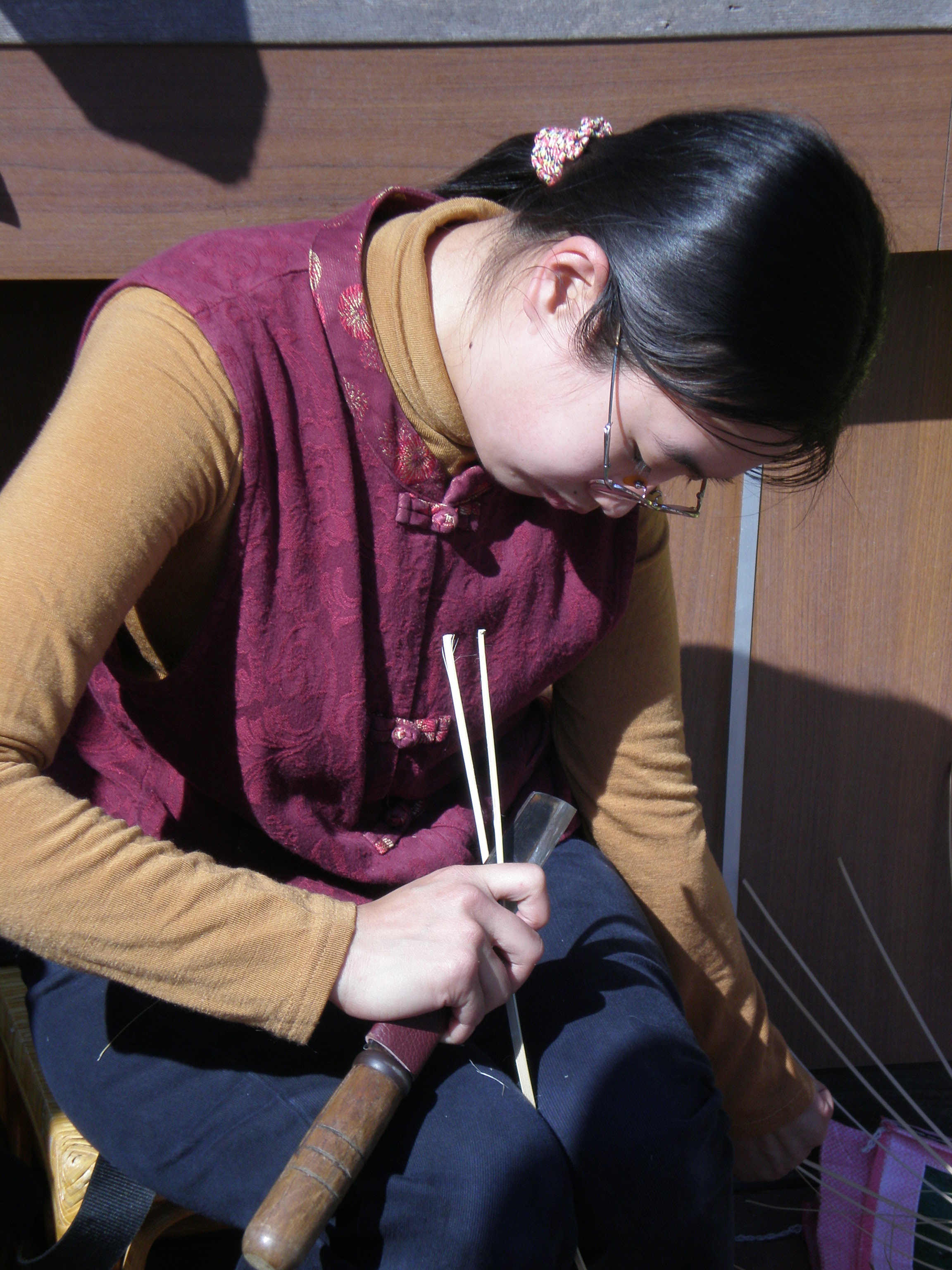 正專注削竹篾的瓊文，這是竹編工藝中最困難的部分。