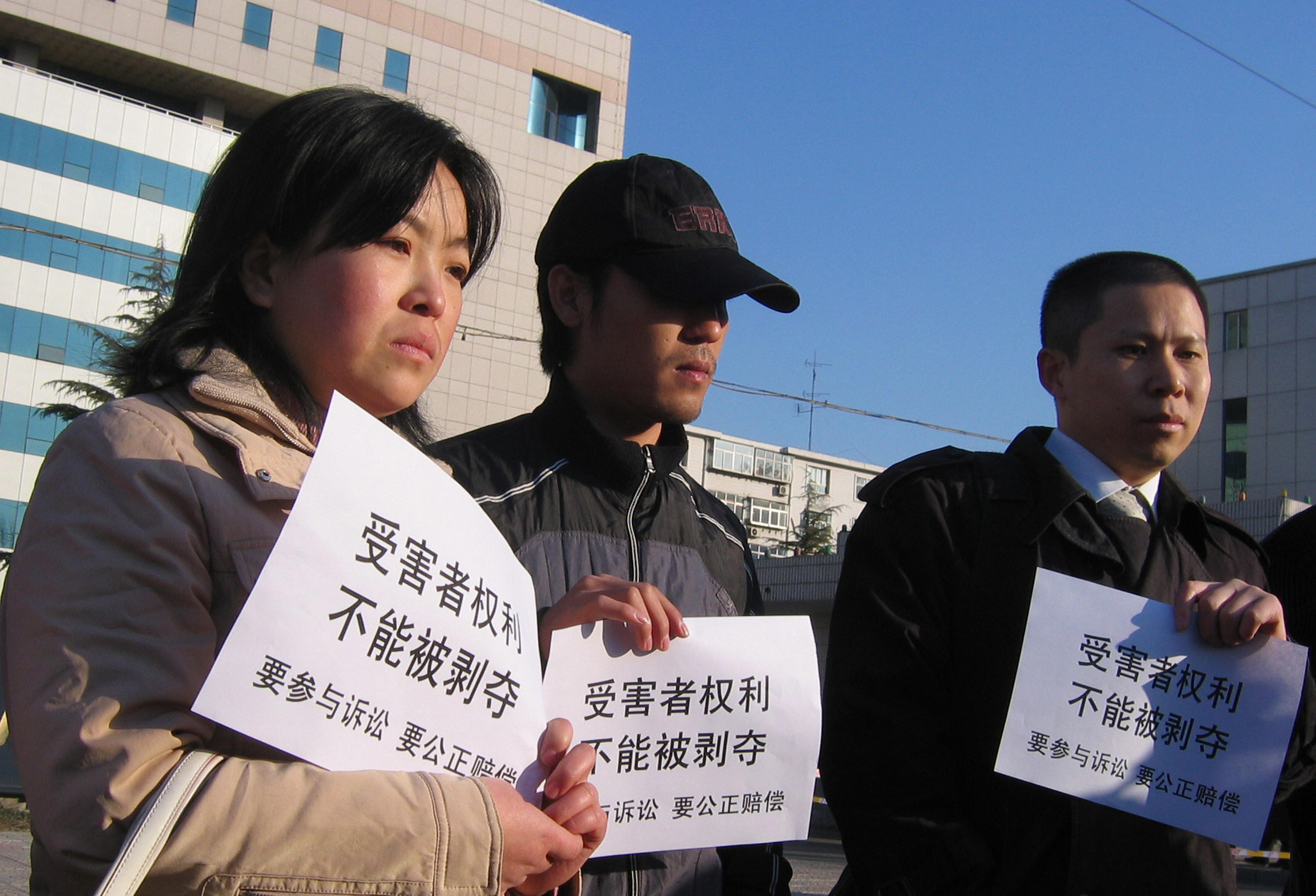 三鹿毒奶粉的受害者親屬2008年12月31日聚集河北省石家莊市法院外，舉起「受害者權利，不能被剝奪；要參與訴訟，要公正賠償」的標語。