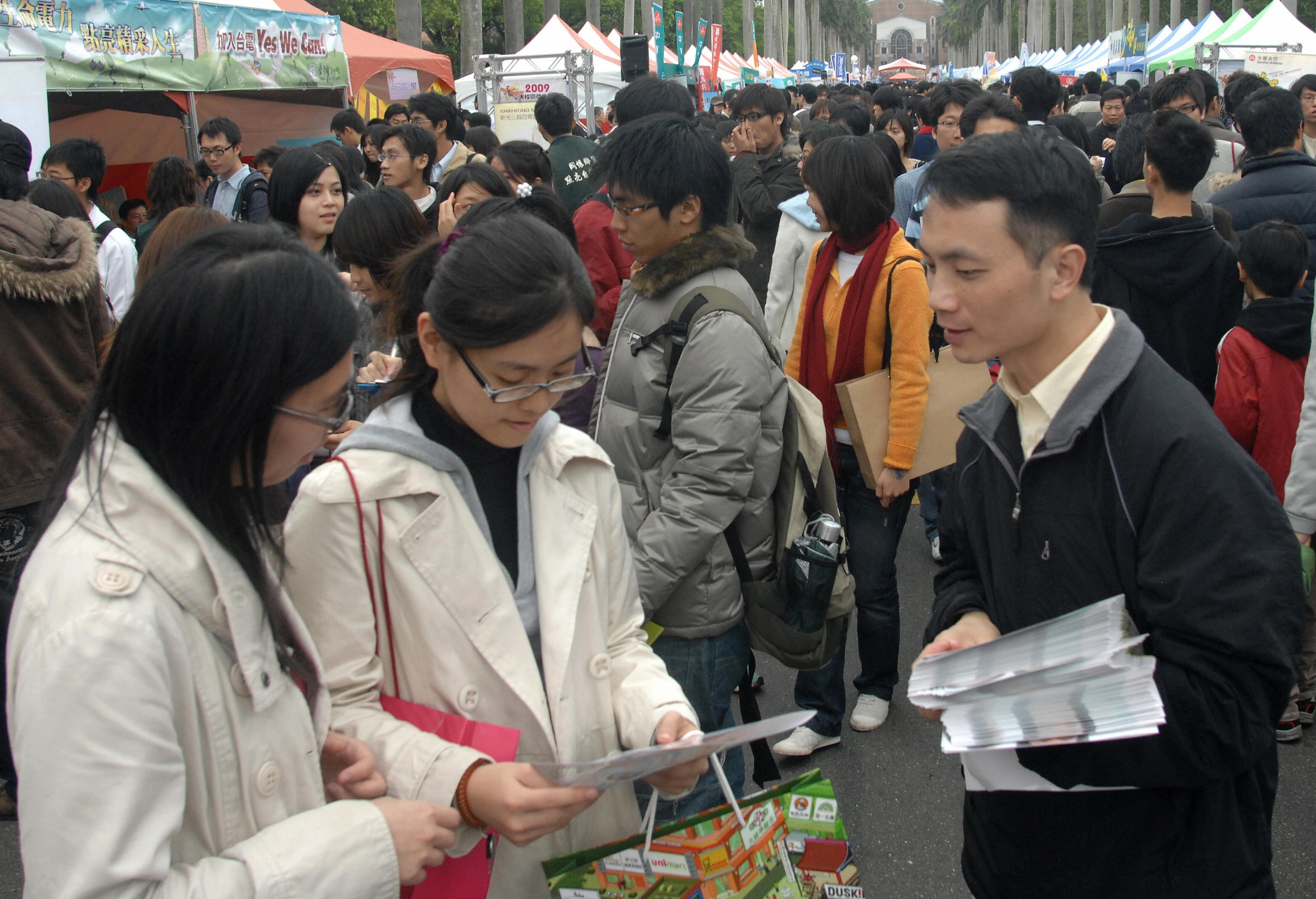 2009台灣大學校園徵才活動，3月8日在台大總校區椰林大道展開，共有162家廠商、188個攤位參與。企業高喊「用愛打敗不景氣」，現場人潮洶湧。