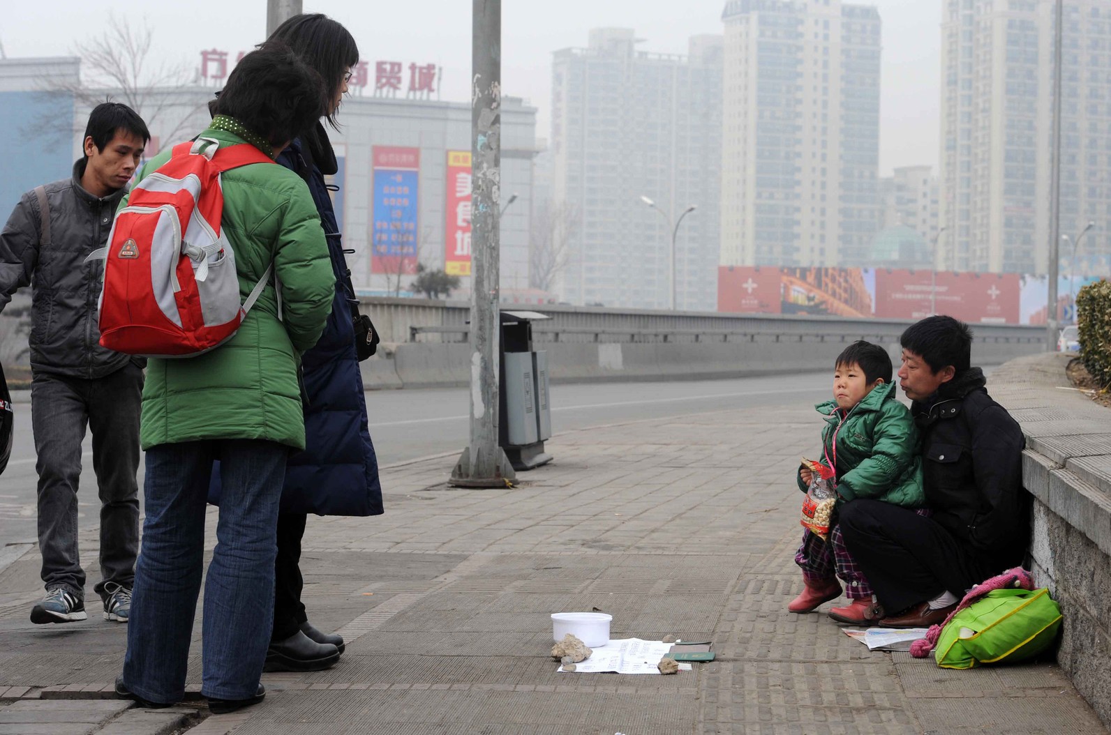 2010年2月25日北京一名無家可歸的男子帶著他6歲的女兒在街上乞討。