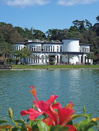 朱槿與俗稱「小白宮」的碧湖公園管理中心遙相輝映，好個晴朗的春日。