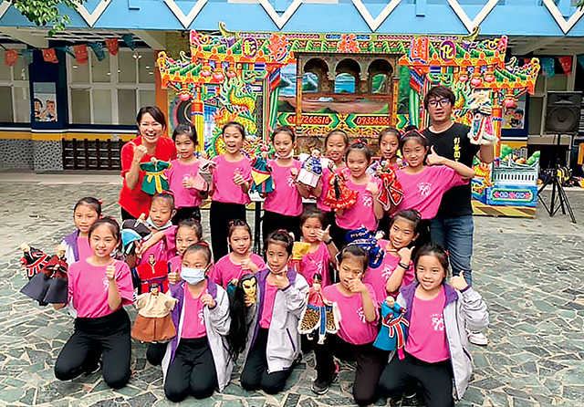 陳韋佑（最後排右）至校園推動布袋戲文化，不遺餘力。彰藝園掌中劇團提供