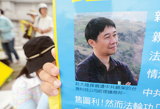2012年8月7日，聲援者在凱達格蘭大道的集會中舉著鍾鼎邦的照片，呼籲台灣政府要求中國當局釋放鍾鼎邦。Getty Images