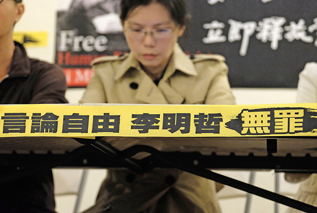 2018年11月10日李明哲的妻子李淨瑜在台北舉行的記者會上掛出「言論自由，李明哲無罪」的橫幅，呼籲中國當局立即釋放李明哲。Getty Images