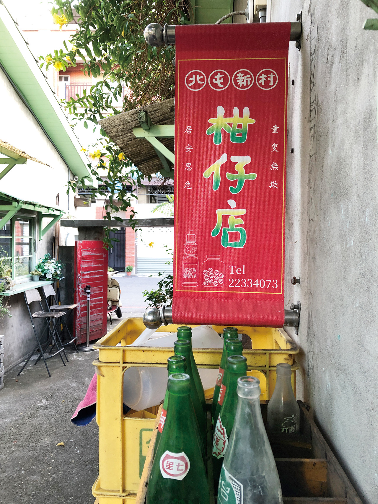 「北屯新村柑仔店」門口懸掛一面「童叟無欺,居安思危」的招牌旗幟。