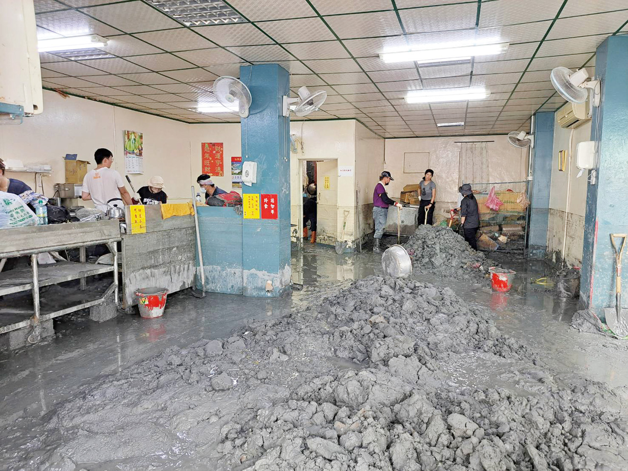 鏟子超人們協助清理災民家中堆積的淤泥。
