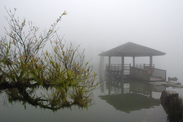 明池終年煙嵐繚繞，湖中涼亭映襯著湖面，如畫如詩。