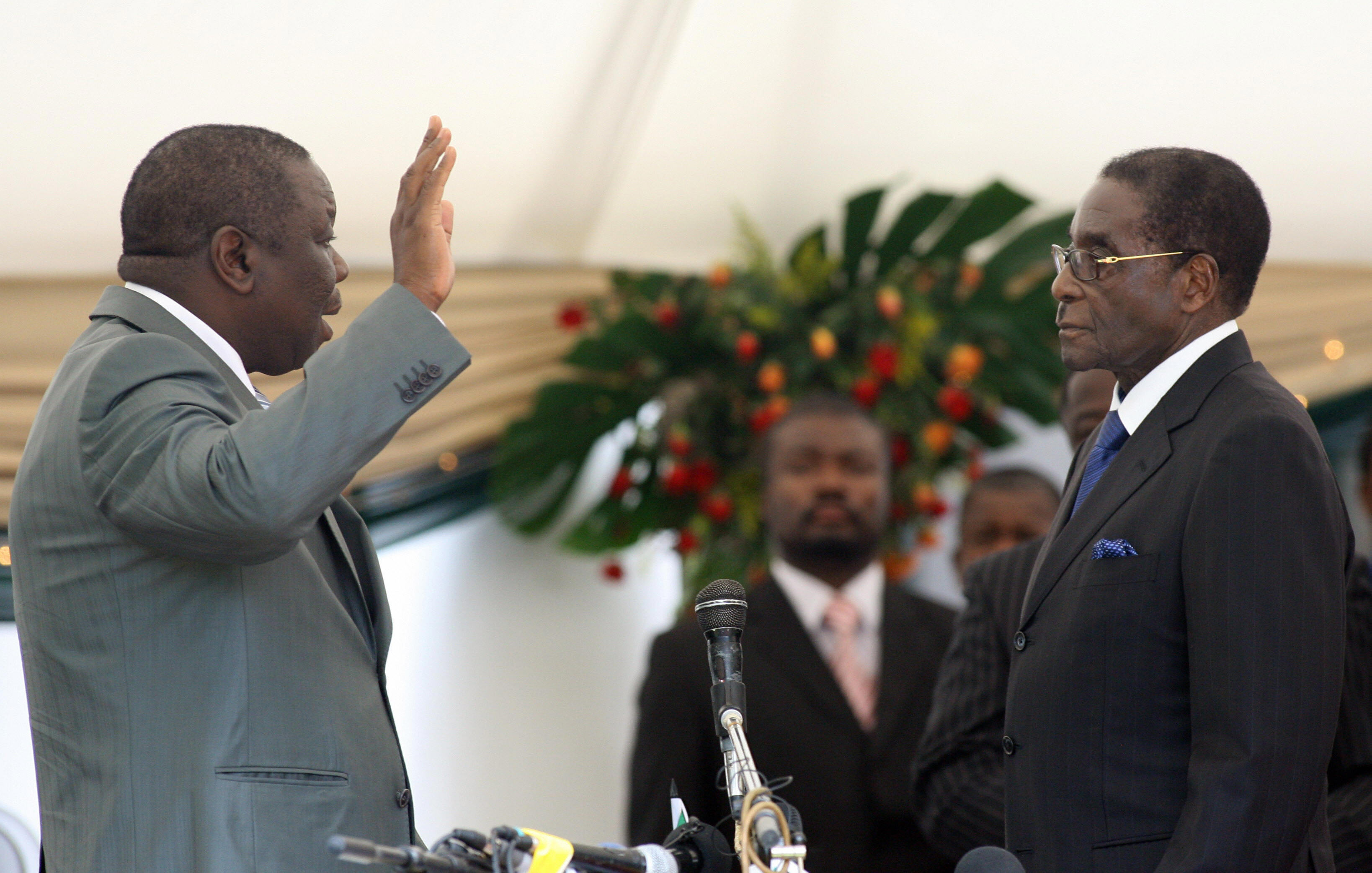 津巴布韦前反对党领袖崔凡吉莱（左）宣誓就任津巴布韦总理，右为总统穆加比。