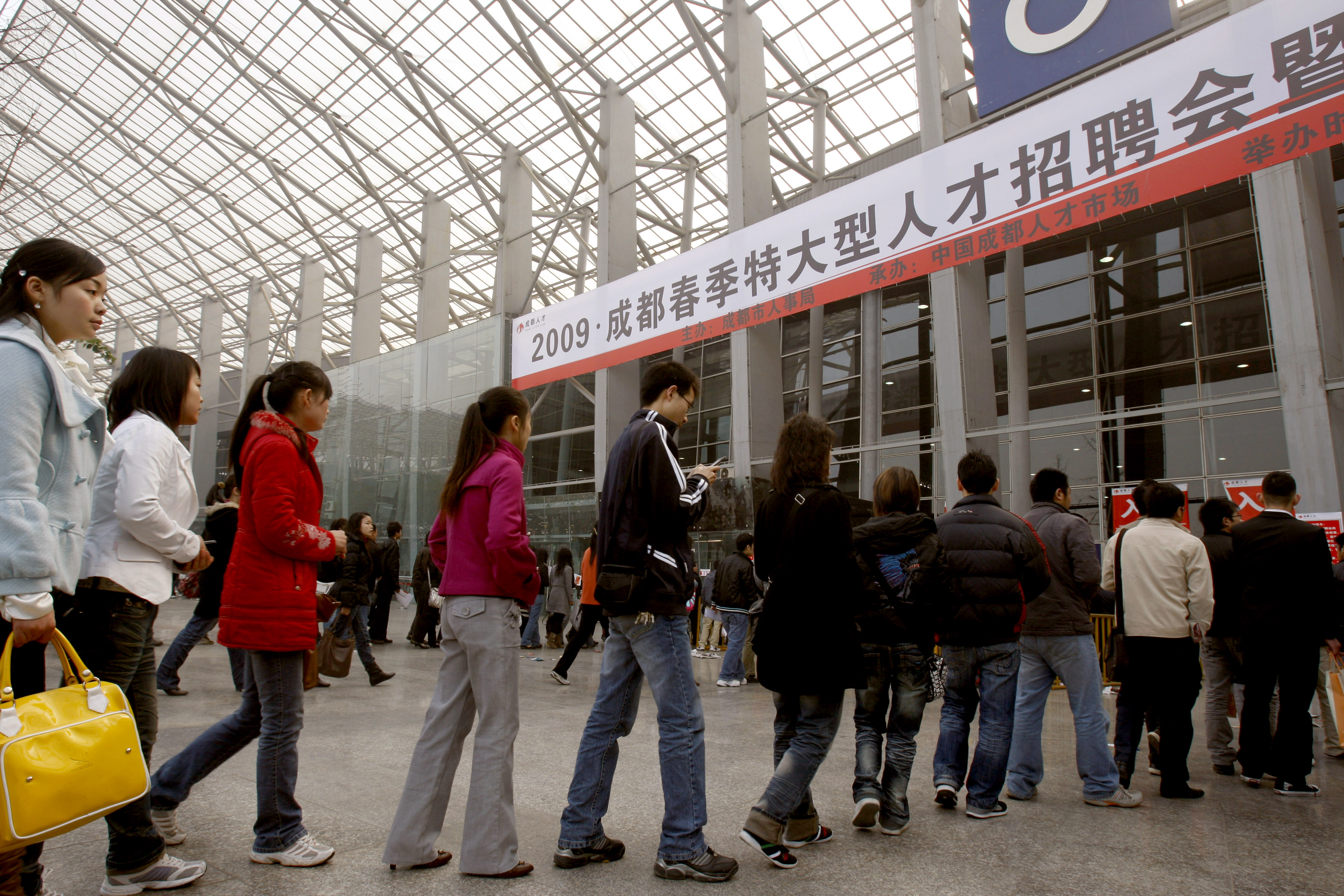 2009年2月14日大批大学毕业生排队参加在四川成都的人才招聘会。官方除帮助大学毕业生找到工作，还对失业移民工人提供免费培训，鼓励他们返回家乡创业。