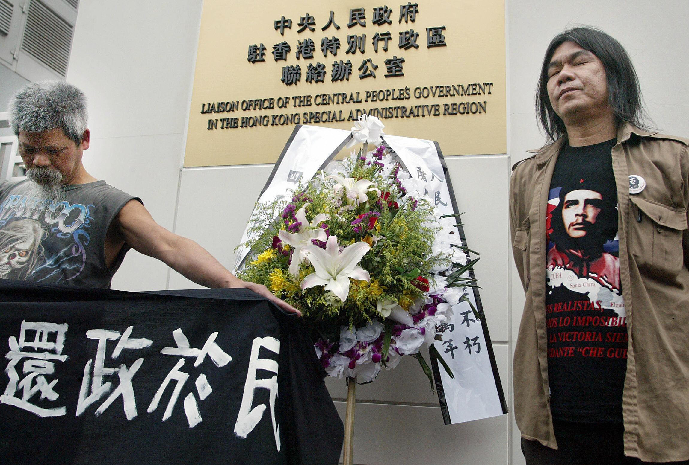 北京最近企圖以「中聯辦」作為第二權力中心干預香港民主。圖為香港民主人士古思堯（左）和地方議員梁國雄（右）2005年4月5日在香港中聯辦前悼念為民主犧牲的中國人並