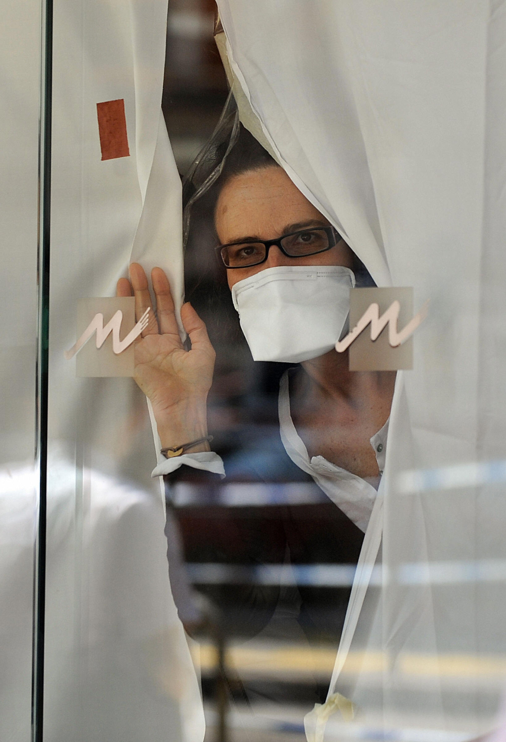 5月6日，一名因H1N1流感疫情被隔離在香港灣仔維景酒店的旅客，從酒店大廳中探頭向外張望。