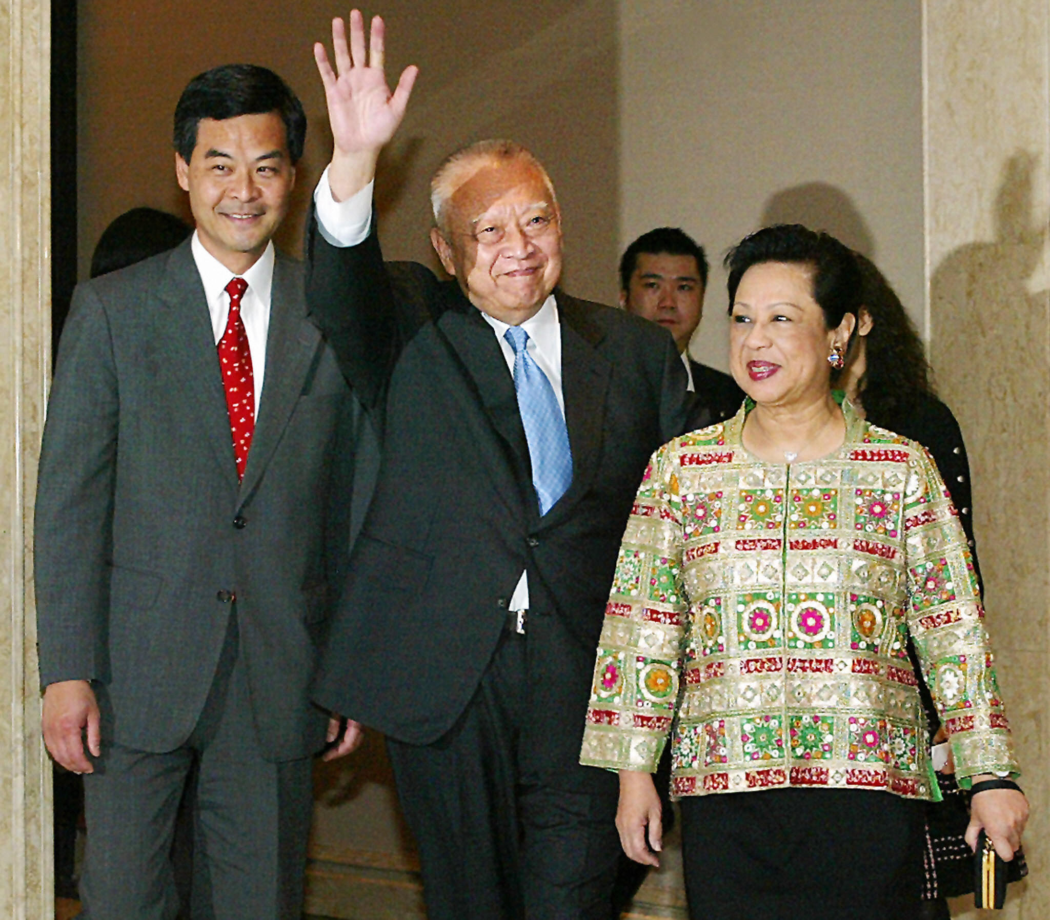 香港前特首董建华（中）因健康为由辞职后，2005年4月7日与妻子赵洪娉（右）一起出席在香港酒店举行的告别宴会。当时陪伴入场者即为担任香港特别行政区行政会议召集人