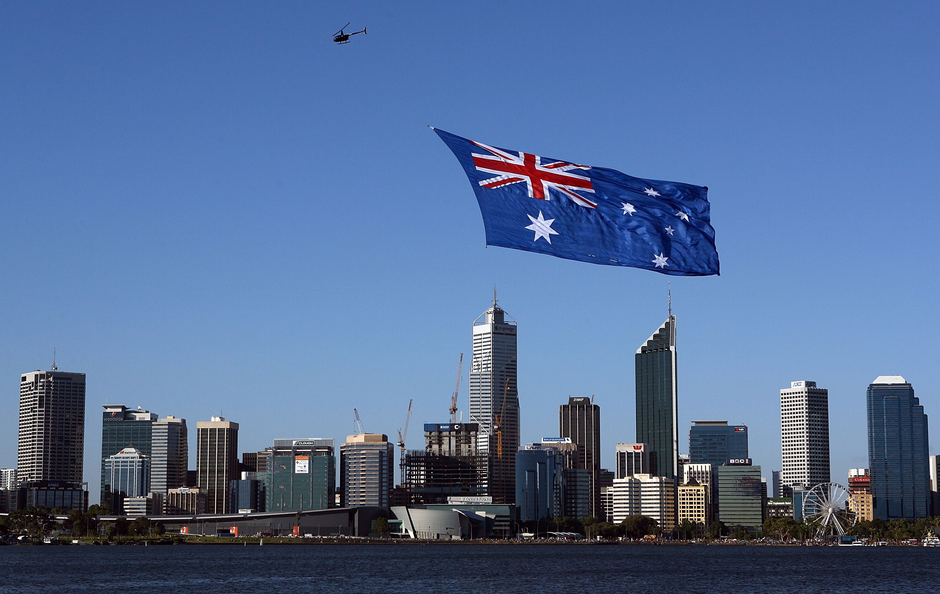 2010年澳洲国庆节，一架直升机拖曳一面澳洲国旗飞越珀斯市上空。
