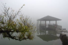 明池終年煙嵐繚繞，湖中涼亭映襯著湖面，如畫如詩。