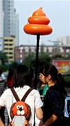 年輕人舉著類似糞便的充氣玩具是今年中國年輕人最時尚的玩具，光成都地區每天可以賣上百個。 