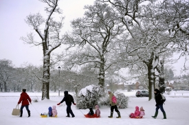 英國下大雪，學童坐在雪橇上，由母親帶著上學。